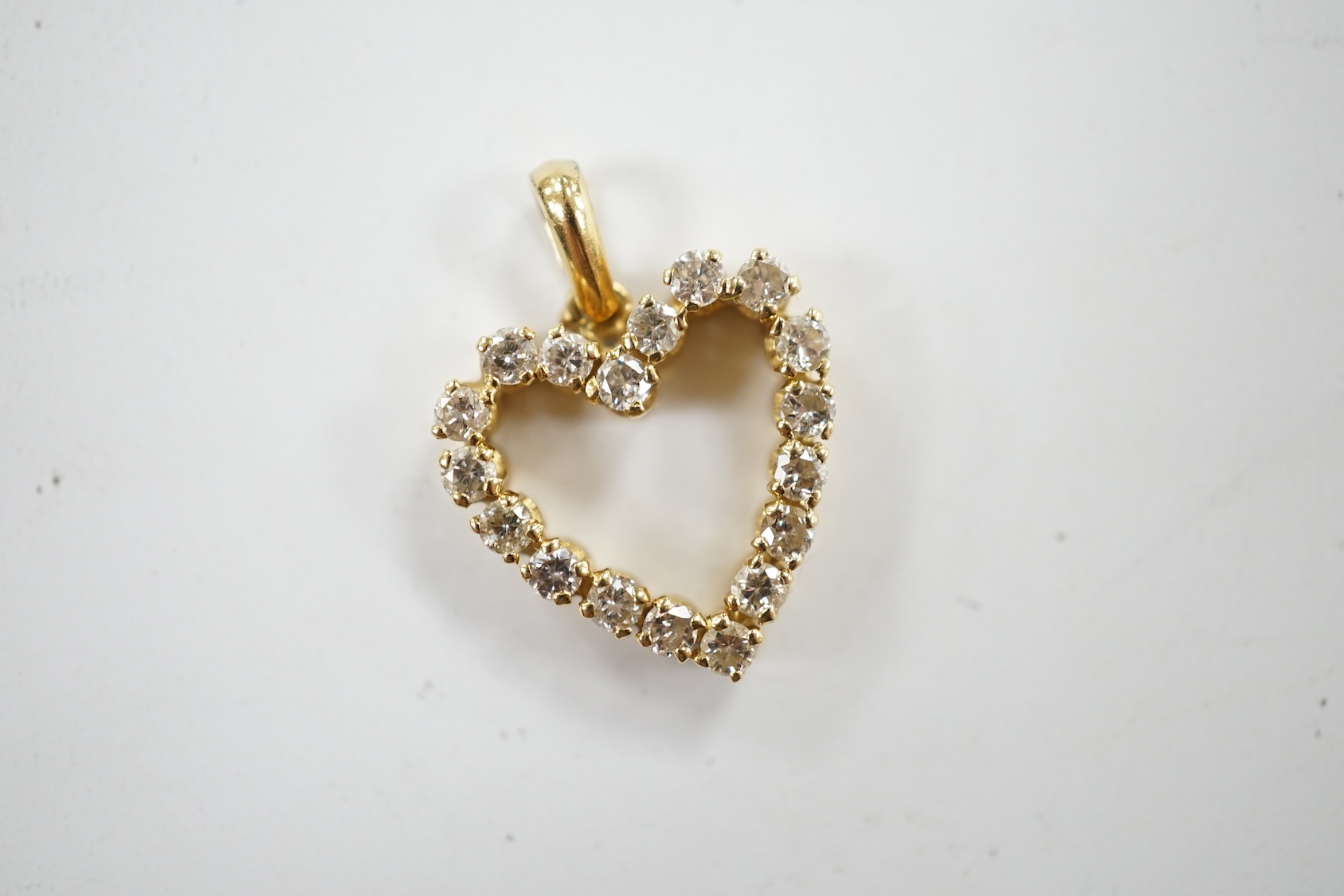 A modern 18k and diamond cluster set open work heart shaped pendant, overall 21mm, gross weight 2.7 grams. Condition - fair to good